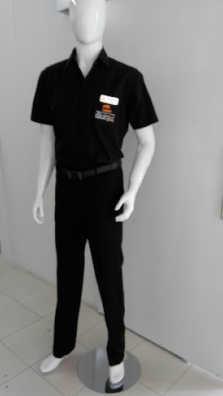 Black short-sleeve shirt with a name badge and black trousers on a mannequin